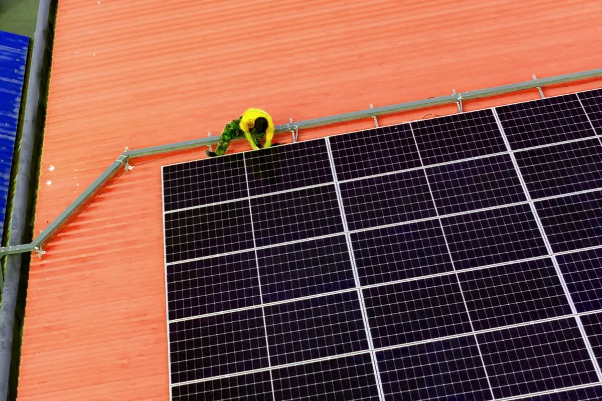 Instalador junto a una fila de paneles solares sobre una cubierta industrial en Guadalajara